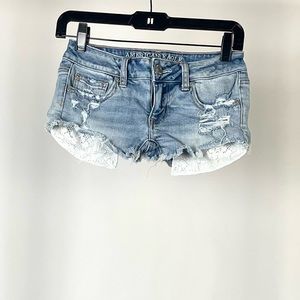 AE Daisy Duke Cutoffs Distressed Light Wash revealing pockets in light blue.